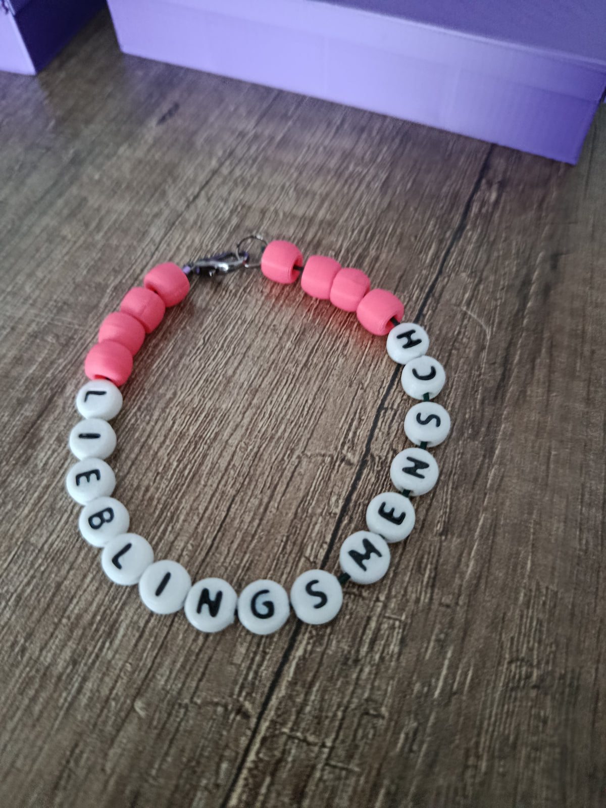 Rosa Perlenarmband mit weißen Buchstabenperlen und individuellem Namen