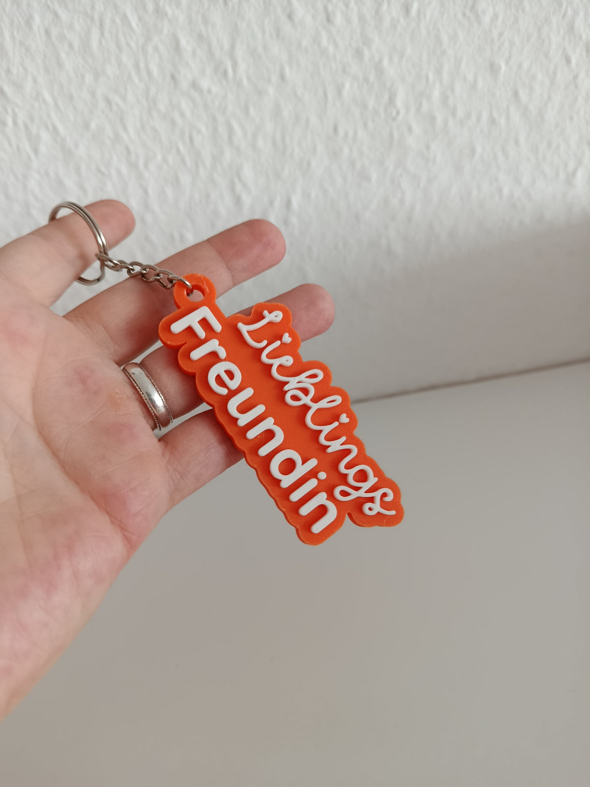 3D-gedruckter Schlüsselanhänger Lieblings Freundin in einer Hand, orange mit weißer Schrift