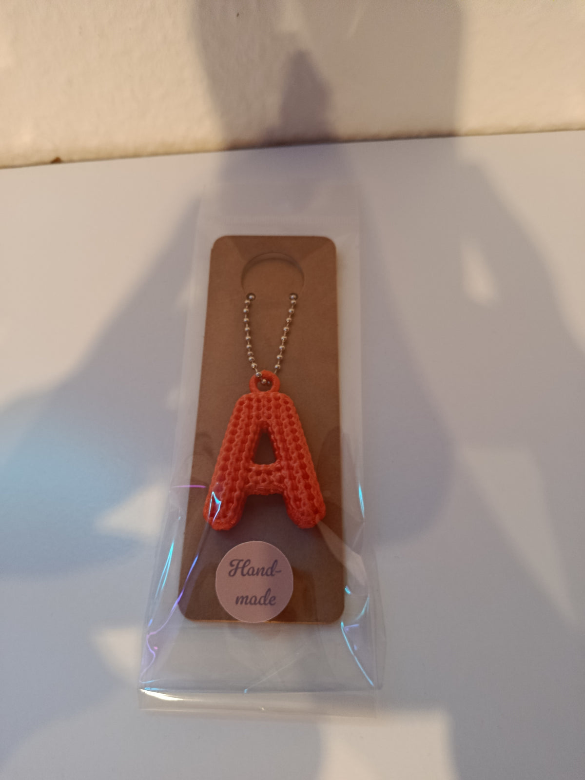 Verpackter roter Schlüsselanhänger mit Buchstabe A und Handmade-Aufkleber